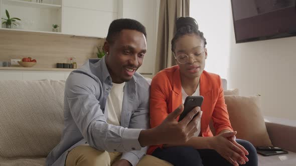 African American Couple Having a Conversation Via a Video Call on the Smart Phone with Their Friends alt