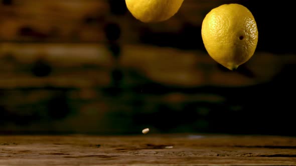 Super Slow Motion Fresh Lemons Fall on the Wooden Table alt