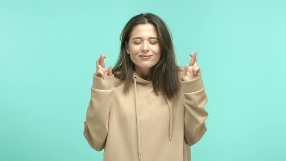 Attractive Young Woman Making a Wish Holding Fingers Crossed and Looking Up Fantasizing About alt