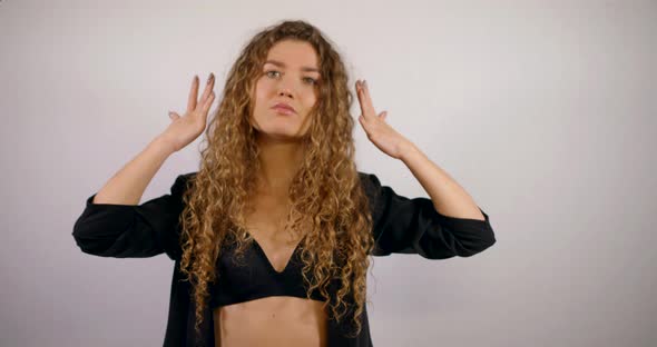 Portrait of a Smiling Curly-haired Girl Who Is in the Studio on a White Background, Wearing a Black alt