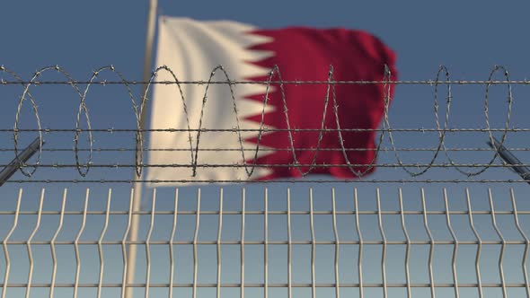 Waving Flag of Qatar Behind Barbed Wire Fence alt