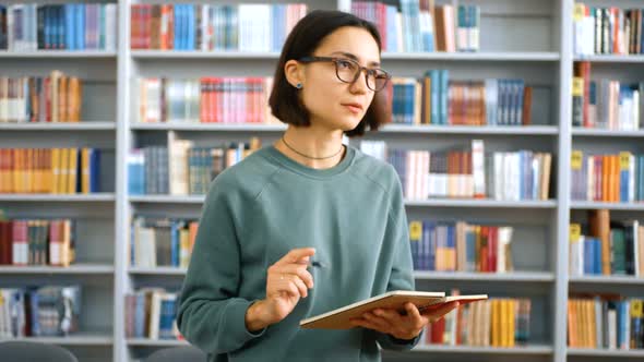 Closeup Portrait of a Young Attractive Female Teacher Teaching a Lesson Reading the Assignment in a