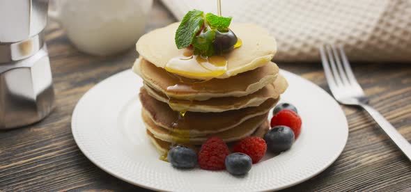 Food and Cooking Concept. Stack of Pancakes with Berry and Warm Maple Syrup in Slow Motion alt