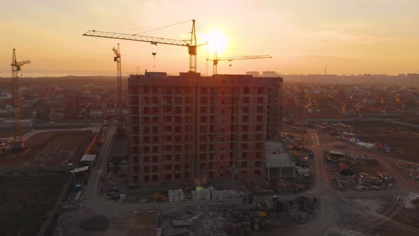 Construction Site in the Middle of the City and Private Houses at Sunset in . alt