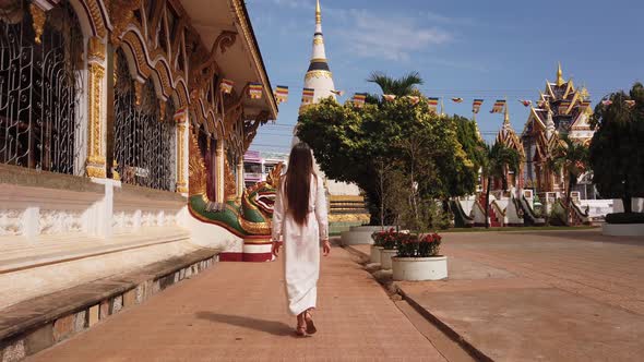 Beautiful woman traveler walking in Buddhist Wat Luang Temple, Pakse, Laos. 4K Slow. Asian culture