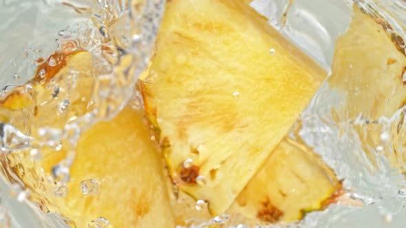 Super Slow Motion Shot of Pineapple Slices Falling Into Water Whirl at 1000 Fps alt