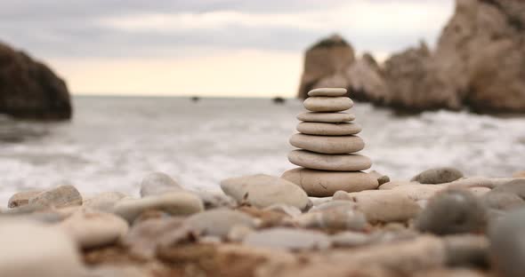 4k video of Pyramid stones on the seashore on a sunny day on the blue sea background. Happy holidays