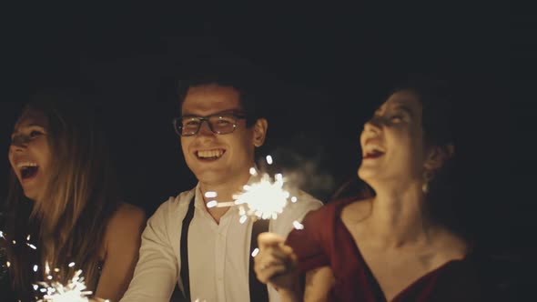 Large Group of Multiracial Friends or Acquaintances Holding and Waving Sparklers alt