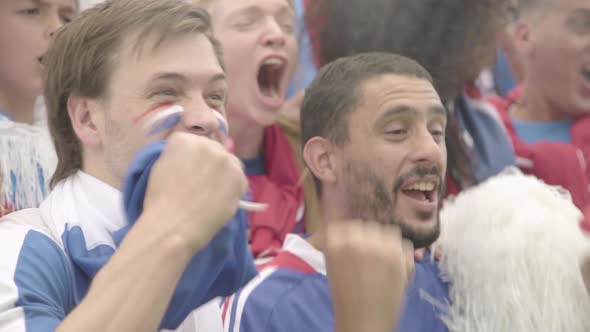 French football fans cheering in excitement at match