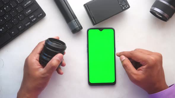 Top View of Man Hand Using Smart Phone and Camera Lens alt