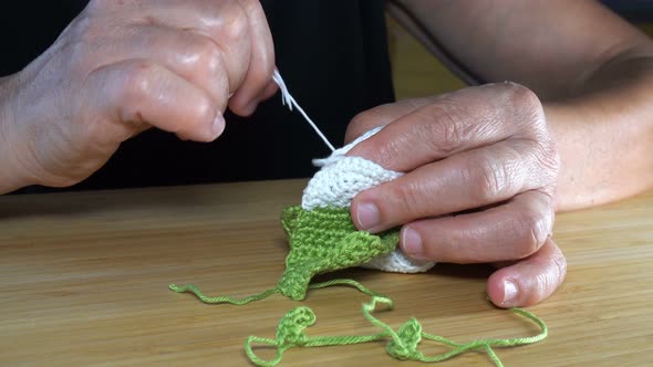 Seamstress is Working with a Crochet Sewing Baby Shoes.