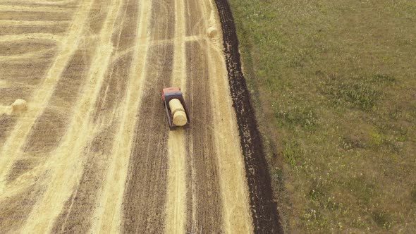 Truck Loading Hay Bales Onto a Parked Truck Aerial View