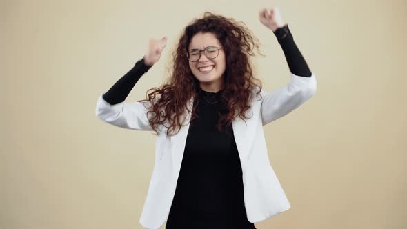 Crazy Young Woman with Curly Hair Dances with Clenched Fists Waving Her Hands and Head alt