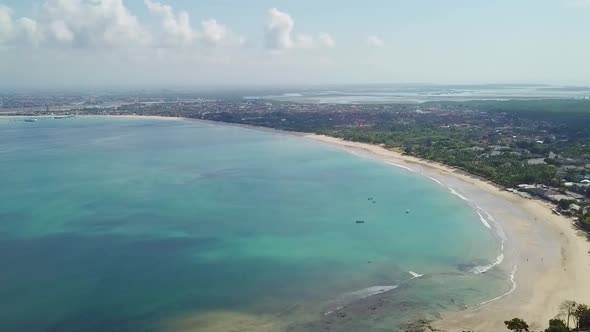 Bali Indonesia Beautiful Jimbaran Bay Beach with Clear Blue Ocean Aerial Panning Drone alt