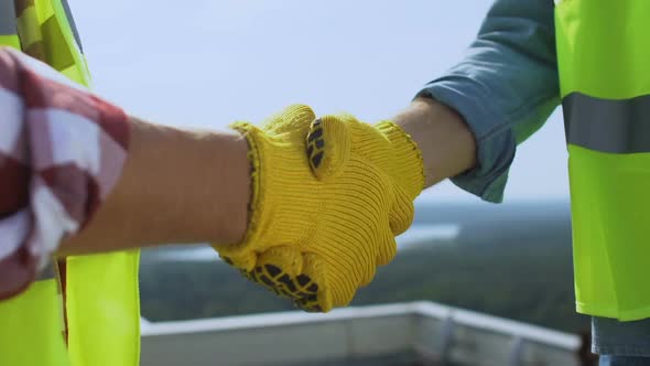 Contractor and Builder in Uniform Shaking Hands on Roof, Work Cooperation, Deal