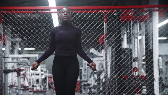 An Africanamerican Woman Jumping Over the Rope in the Gym  Endurance Exercises alt