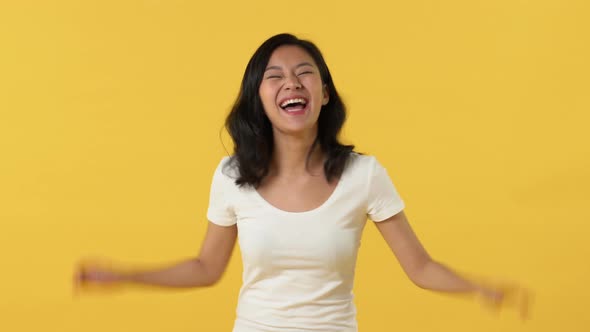 Portrait of happy young beautiful Asian woman in good mood laughing and looking at camera