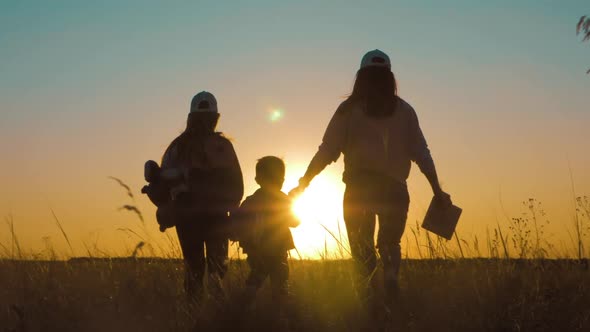 Happy Family Mom and Children Silhouettes Playing on Park alt