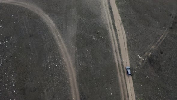 Aerial Shot High Speed Suv Automobile Riding on Countryside Road at Meadow Approaching to Cliff alt