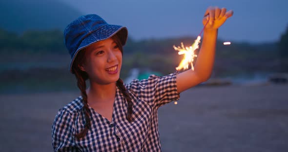 Woman play with sparklers in the summer time at outdoor alt