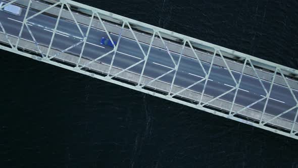 Bird's Eye View of a Bridge Spanning a Fast Flowing Dark River alt