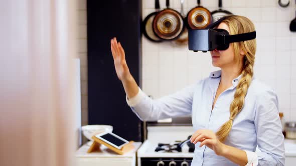 Woman using virtual reality headset in kitchen alt