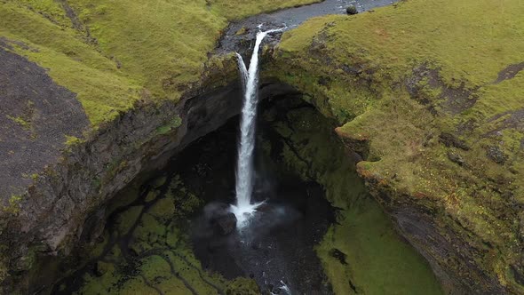 thin waterfall in the mountains of iceland alt