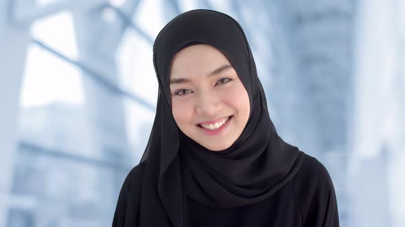 Portrait beautiful Muslim woman wearing traditional clothing laughing with shyness