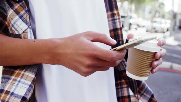A man texting and drinking coffee alt