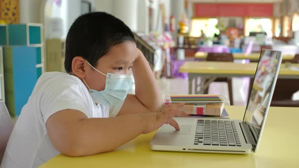 Back to School, Online learning, Asian little child with face mask using laptop computer
