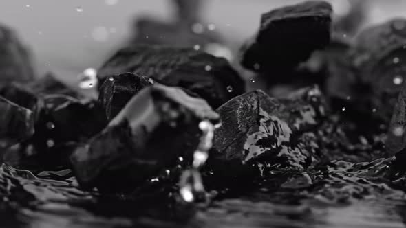 Super Slow Motion Shot of Coal Falling Into Water at 1000 Fps. alt
