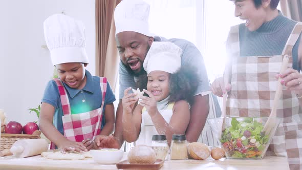 Happy black family having fun and cooking together in kitchen at home