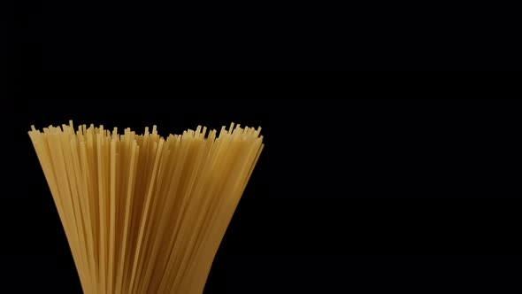 Raw spaghetti rotating on black background