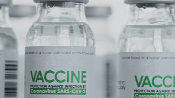 Flasks of vaccine for COVID-19 coronavirus cure are slowly rotated in research lab. Looped alt