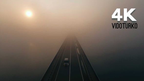 Bridge and river in heavy fog at sunrise