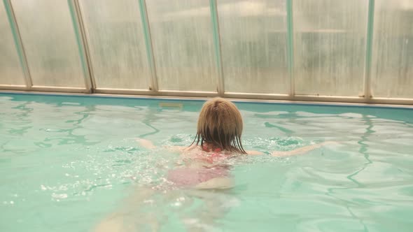 The woman swims in the pool. Swimming is good for health alt