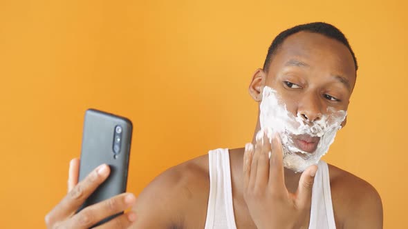 Nice Person with Dark Skin Applies Shaving Foam to the Face Before Shaving the Stubble Use the