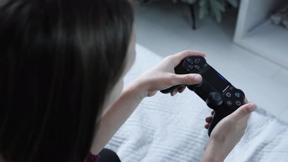 Girl playing video games with wireless controller alt