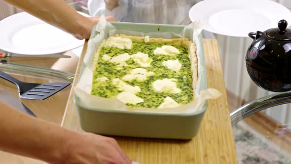 Close Up Woman Puts on Table Freshly Baked Spinach Quiche, Family Dinner