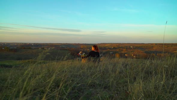 Young Girl and American Staffordshire Terrier Sitting in Meadow at Sunset alt