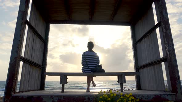 Girl on a Bench By the Seashore on Sunset