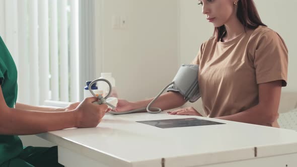 Woman Getting Blood Pressure Checked in Clinic alt