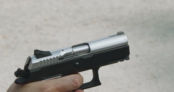 Pistol shooting bullets in slow motion footage. Hand guns in firing range alt