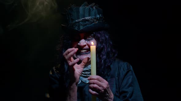 Frightening Creepy Senior Woman with Halloween Witch Makeup Looking at Candle Conjure Hex Wiz alt