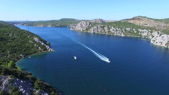 Speedboat passing through deep dark blue sea canal, Croatia alt