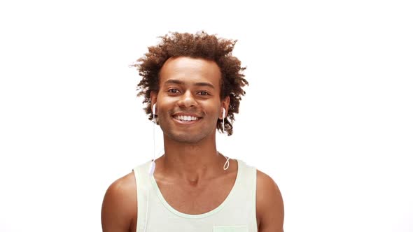 Man Smiling Listening Music in Headphones Over White Background Slow Motion