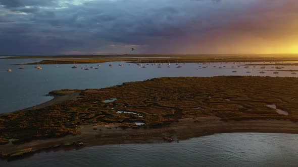 An aerial flight over the salt marshes at West Mersea, Essex just before a storm with dramatic light alt