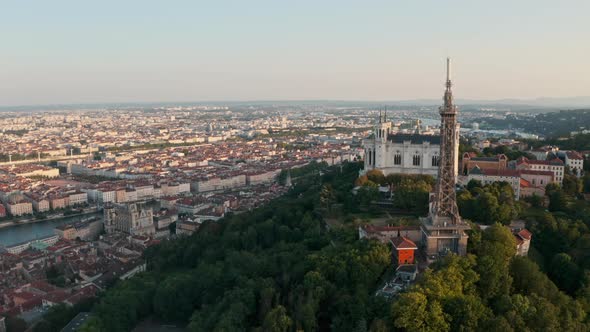 Establishing circling drone shot around the basilica of Lyon and transmitting tower France at sunset alt