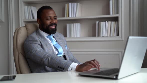 African-American Bearded Man in a Gray Suit and Shirt. The Businessman Is in a Bright Office at the alt