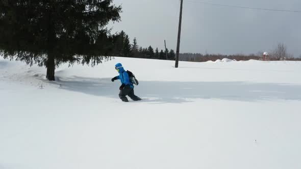 Aerial View of a Snowboard Going Uphill Near the Village at Sunset alt
